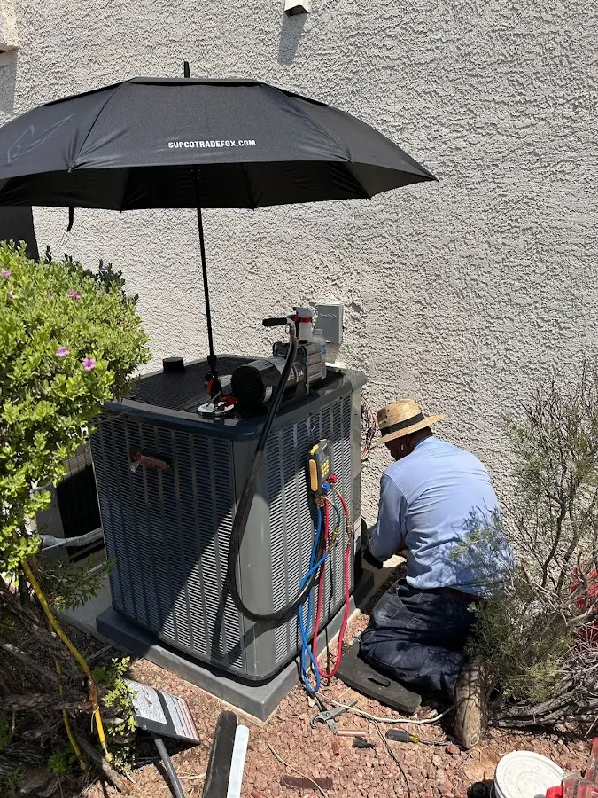 HVAC technician performing outdoor AC maintenance in Randolph Town