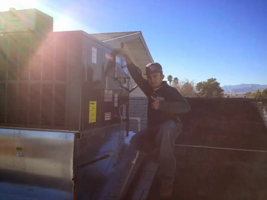 HVAC technician performing AC Tune-Up on a rooftop unit in Randolph Town
